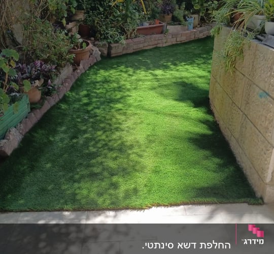 התקנת דשא סינטטי בשביל גינה לצד ערוגות צמחייה ועציצים
